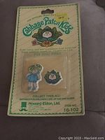 Original packaged Cabbage Patch Kids pin and ring set, showing front packaging with branding and item information.