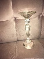 Full view of a clear crystal candle holder with distinct faceted and textured design