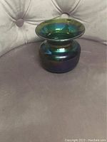 Overall view of the teal green carnival glass spittoon showing shape and iridescent finish.