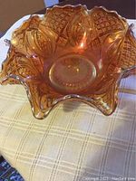 Top-down angled view of the marigold carnival glass bowl showing the ruffled edge and diamond ring pattern with iridescent finish.