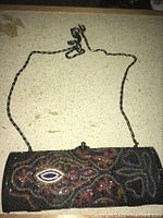 Full view of the vintage beaded clutch bag with attached chain strap laid flat