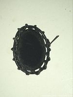 Photo showing the back of the vintage oval cameo brooch with metal frame and old pin mechanism needing repair.
