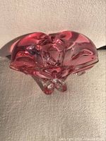 Top view of the cranberry art glass sculpture showing the flowing, organic shape and rich color.