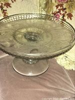 Top down photo showing clear glass cake stand's decorative patterns and bead edge