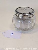 Front and top view of the glass dresser jar with sterling silver lid showing the engraved monogram 'H.C.' on the lid and 'From H.G.C. 1899' inscription near hallmark