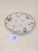 Photo of the 8.5 inch Limoges porcelain plate showing floral pattern and gold scalloped edges.
