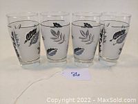 Four clear glass tumblers with silver foliage print, arranged in a row showing designs on each glass.