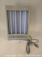 Front view of one Sun Touch Plus light therapy box showing six vertical fluorescent tubes, vented bottom section, and power cord.