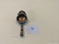 Photo of tea strainer overall showing shape and perforated bowl with handle and attached tag
