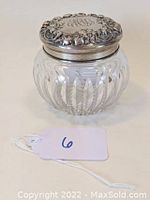 Front view of the glass powder jar with ornate sterling silver lid monogrammed MAL.