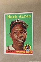 Front of card showing Hank Aaron portrait, green background, yellow name text and team logo