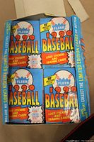 Top view of open 1990 Fleer Baseball wax box showing 36 unopened blue wax packs inside with red and yellow text graphics