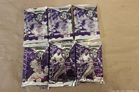 Six sealed 1994 Donruss Major League Baseball card foil packs arranged in two rows of three on a beige surface.