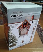 Boxed snowy cabin cuckoo clock showing packaging with product image and branding
