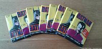 Eight unopened 1989 Batman trading card wax packs laid flat, five showing Batman on cover and three showing Joker, all with original packaging intact.