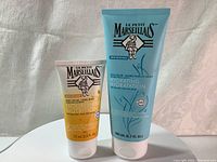 Photo of two tubes of Le Petit Marseilliais products: hand cream and body balm side by side showing front labels.