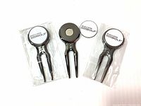 Three new golf divot repair tools with detachable magnetic markers featuring Skechers GOGOLF branding in original packaging, shown front view.