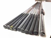 Photo showing 11 golf club shafts arranged in a row with grips visible, including Golf Pride and Super Stroke grips.