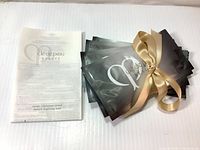 Set of 12 Shiseido Cle De Peau Beaute Intensive Brightening Masks, tied with a beige ribbon and shown next to an informational insert.