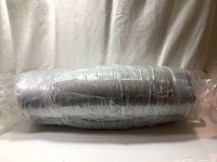 Factory sealed Endy day bed mattress rolled and wrapped in protective plastic.