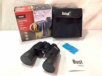 Full lot including original box, binoculars, soft carrying case, cleaning cloth, and user manual laid out on fabric surface.