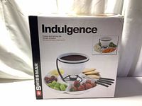 Box front showing Swissmar Indulgence ceramic fondue and serving set including fondue bowl, divided tray, and forks