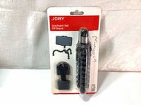 Front view of the Joby GripTight ONE GP Stand in original retail packaging. Shows the flexible black tripod with segmented legs and the smartphone holder attachment.
