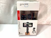 Front view of the boxed Joby GorillaPod GripTight Action Kit with visible mounts and remote inside plastic window.
