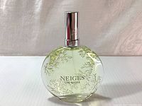 Front view of Neiges Lise Watier perfume bottle showing floral etching and label.