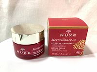 Photo of Nuxe Merveillance Lift Citrus Cells Glow Rich Moisturising Cream 50ml in red glass jar with silver lid alongside the original box showing front branding and product name.