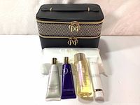 Full set including Shiseido bag, 4 skincare products and package of cotton sheets on white surface.