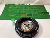 Complete set including green felt betting mat, black roulette wheel, and a timer with 3 different size balls inside for roulette game play.