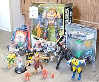 Wide view of assorted action figures including large boxed Galaxy Wars robot, smaller hero/villain figures, and small soldier archer.