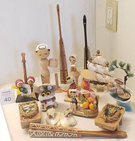 Lot of assorted vintage Asian style Art Deco hand-carved wooden figurines and decorative miniatures displayed on table.