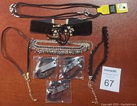 Top view of all necklaces and packaged bracelets on brown surface, showing variety in styles and materials