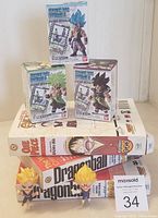 Three boxed Dragonball Z collectible figures plus two comic books stack with two loose mini figures in front