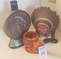 Photo showing all 3 items: Native Indian Chief statue, Jim Beam whiskey decanter, ceramic pipe planter with planter number tag.