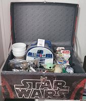 Full lot in a large Star Wars branded storage box, showing lunch bag, cup toppers, figures, and additional items.