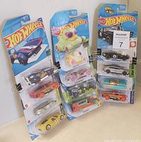 Group photo of 12 brand new Hot Wheels cars in original packaging arranged vertically and horizontally.