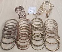 Top-down view of the full lot of women cuff bracelets and Indian bangles arranged in rows on fabric.