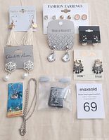 Overview photo of all jewelry items laid out to show the collection including earrings, necklaces, and nose studs.