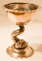 Side view of the antique silver bon bon dish showing the twisted fish stem and decorative round base with scalloped edge.