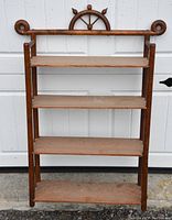 Full front view of the antique wooden hanging shelf showing four shelves and carved nautical top detail.
