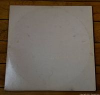 Photo of the white album cover showing minor wear and faint embossing of The Beatles text