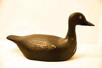 Side profile of black duck decoy showing original paint wear and shape
