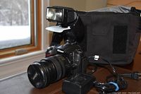 Overall setup with Nikon D90 camera body attached to 18-70mm lens, SB-50DX flash, battery charger and camera bag