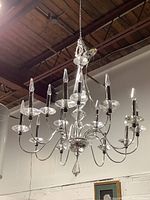 Full view of the 2 tier dining room chandelier showing 14 bulbs and clear glass accents with chrome body hanging from chain