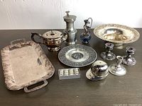 Overview of all items in the lot showing variety of silverplated and pewter tableware with visible wear and tarnish