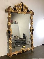 Full view of the large rectangular mirror with detailed carved wood frame and gold leaf grape and vine decorations