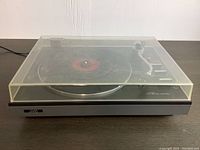Front view of the vintage JVC turntable with the dust cover closed, showing overall condition and JVC logo on front.